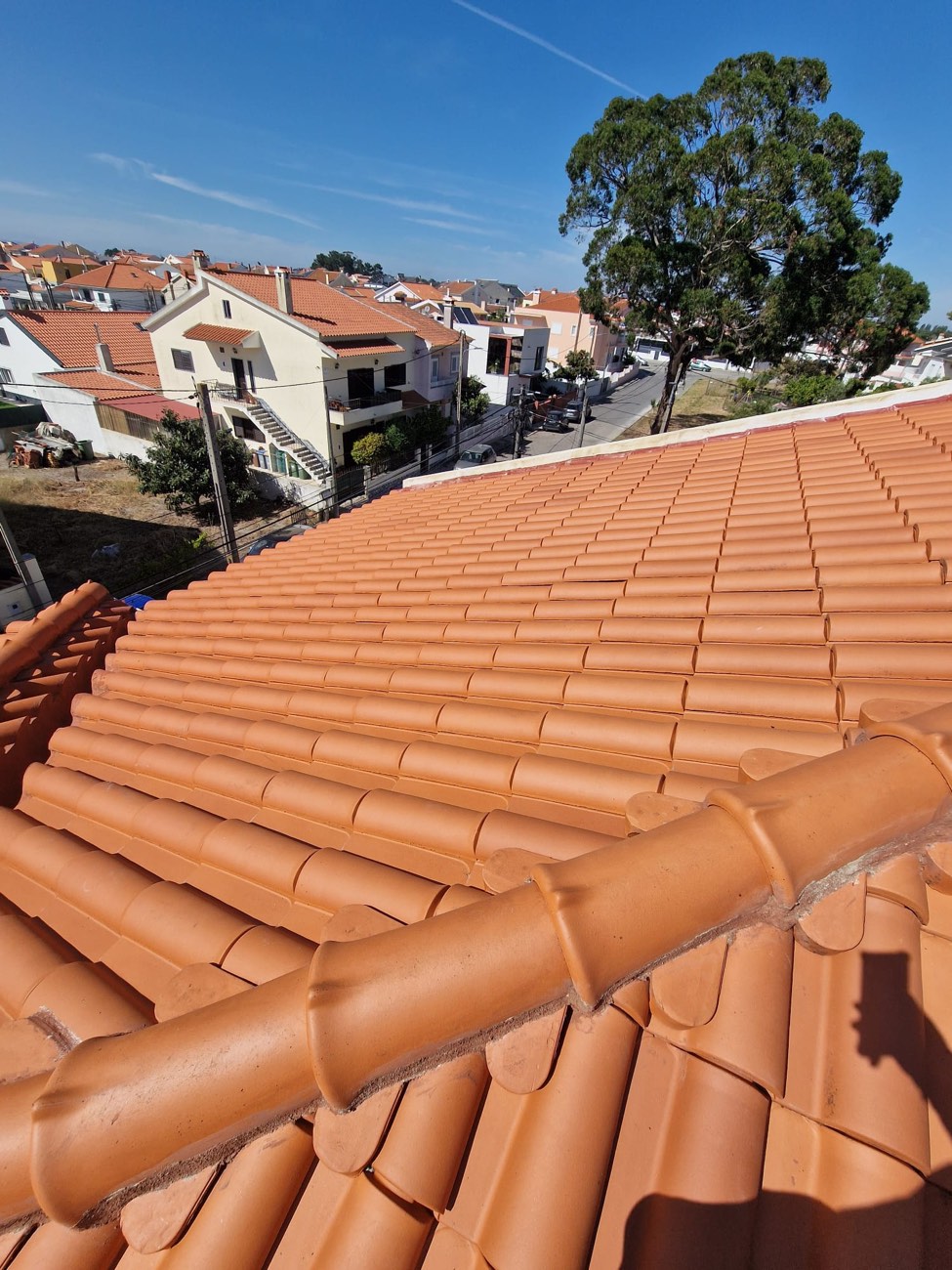 Telhado de telha cerâmica limpo, com vista para o bairro